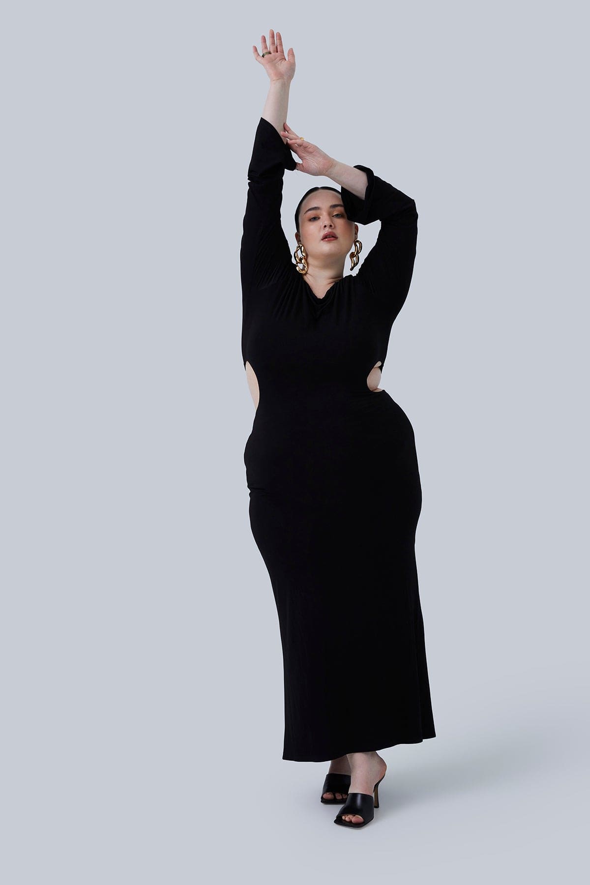 Model standing with arms reaching up overhead in the Gabrielle Maxi size 2X. Dress is super comfortable, sexy, glam and is perfect for a night out or special occasion. Plus size boutique and fashion for women size 12-26.