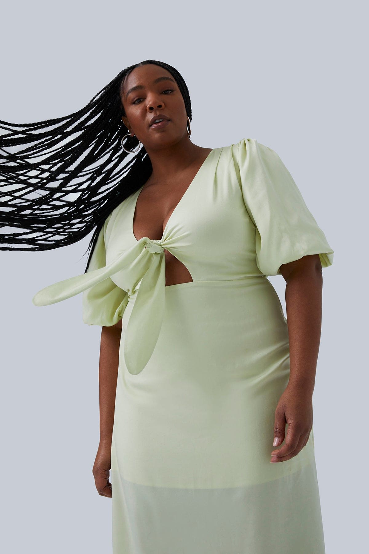 Model swinging long braids to the side wearing Allie Maxi Dress citron size 14. Dress designed by Gia IRL plus size fashion for women size 12-26.