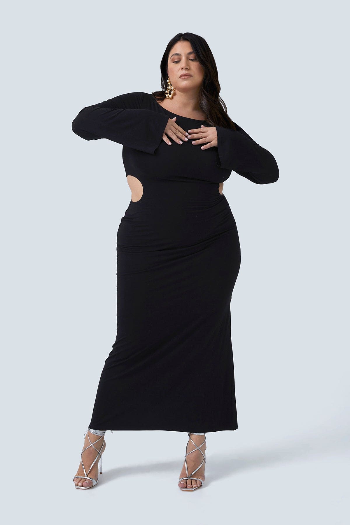 Plus size dress for women size 12-26. Gabrielle Maxi by Gia IRL plus size boutique. Model is standing with both hands on her heart. Model has hourglass figure.