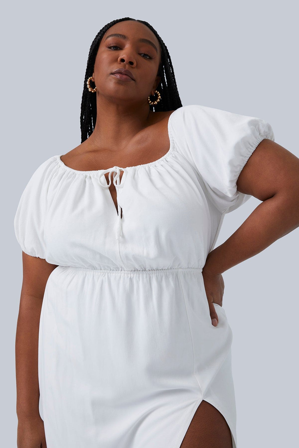 Close up and slightly lower angle of plus size model wearing Gia Midi Dress in White. One hand on hip and head tilted back. Dress can be worn on or off the shoulder. Size 12-26 avaialble.
