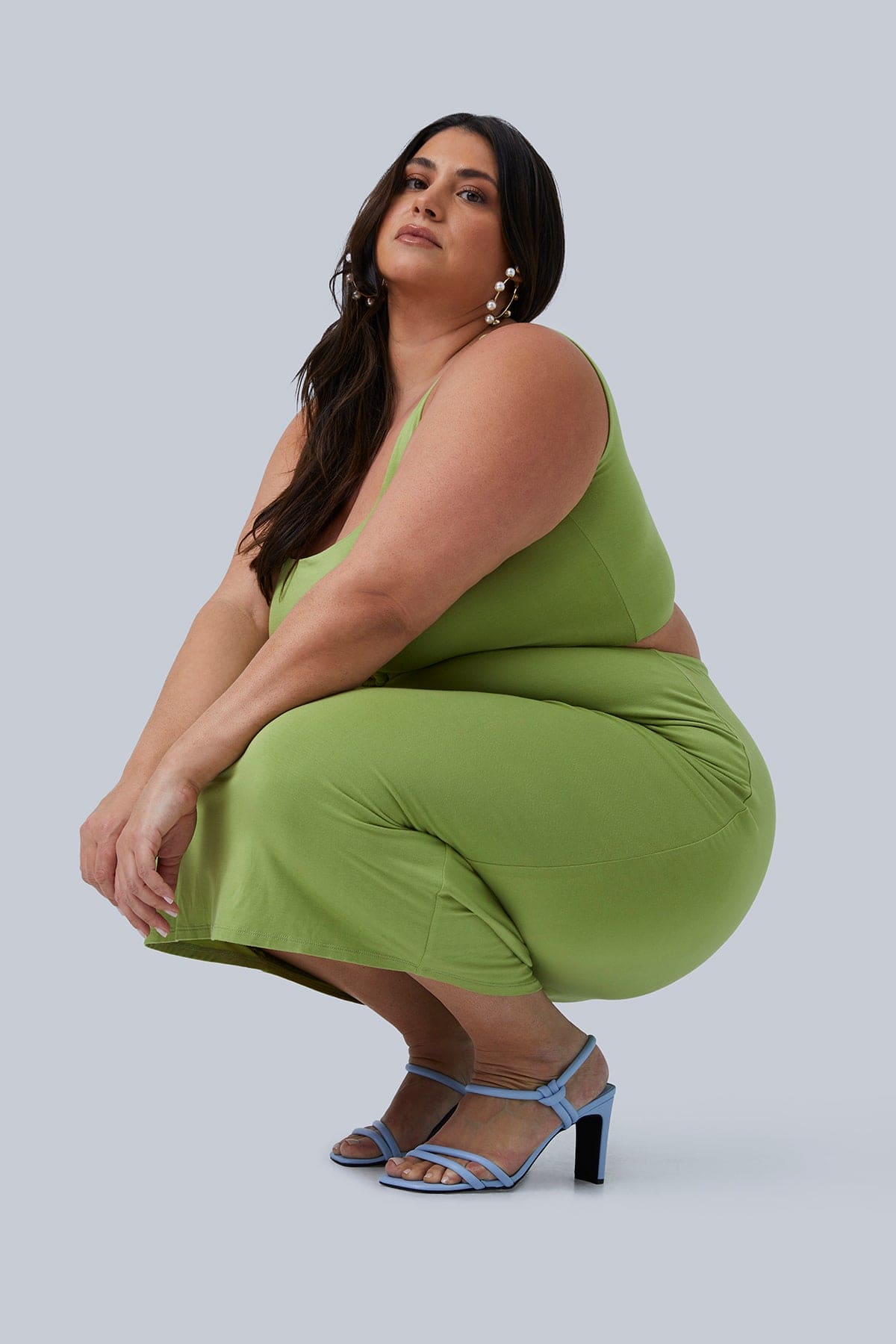 Founder of Gia IRL, Gia Sinatra, squatting and posing in Gigi Midi Dress size 1X from her Plus Size Boutique Gia IRL! The best plus size fashion for women available on the market.