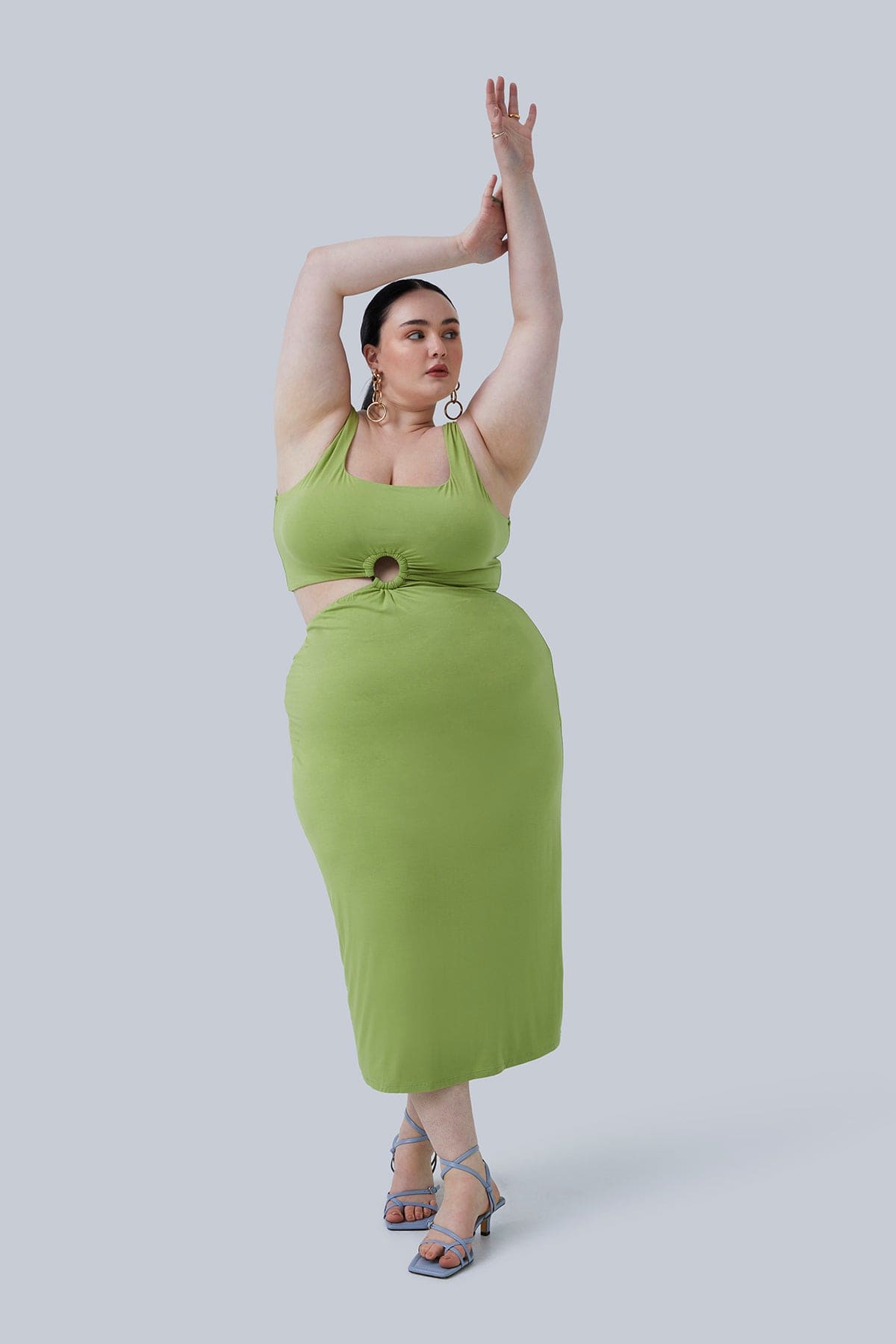 Plus size boutique model with arms reaching up in the air showing the full look of the Gigi Midi Dress size 2X by Gia IRL. Dress is paired with light blue strappy, low heels and simple gold jewelry.